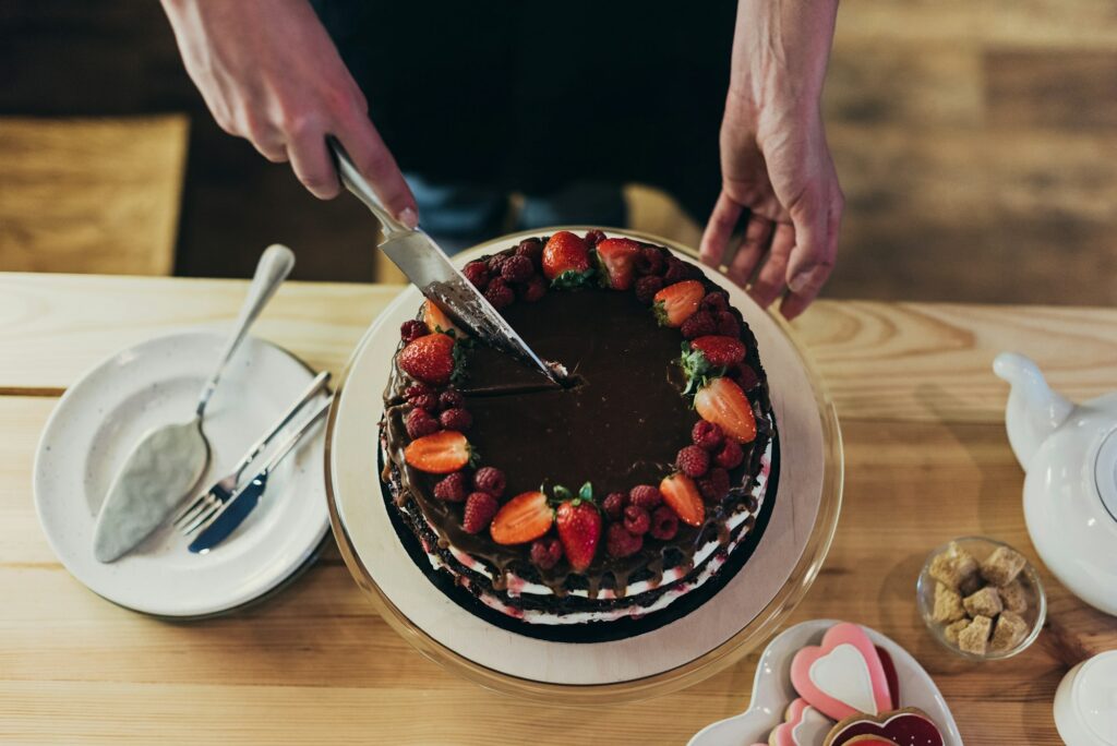 Cropped image of woman cutting delicious chocolate cake