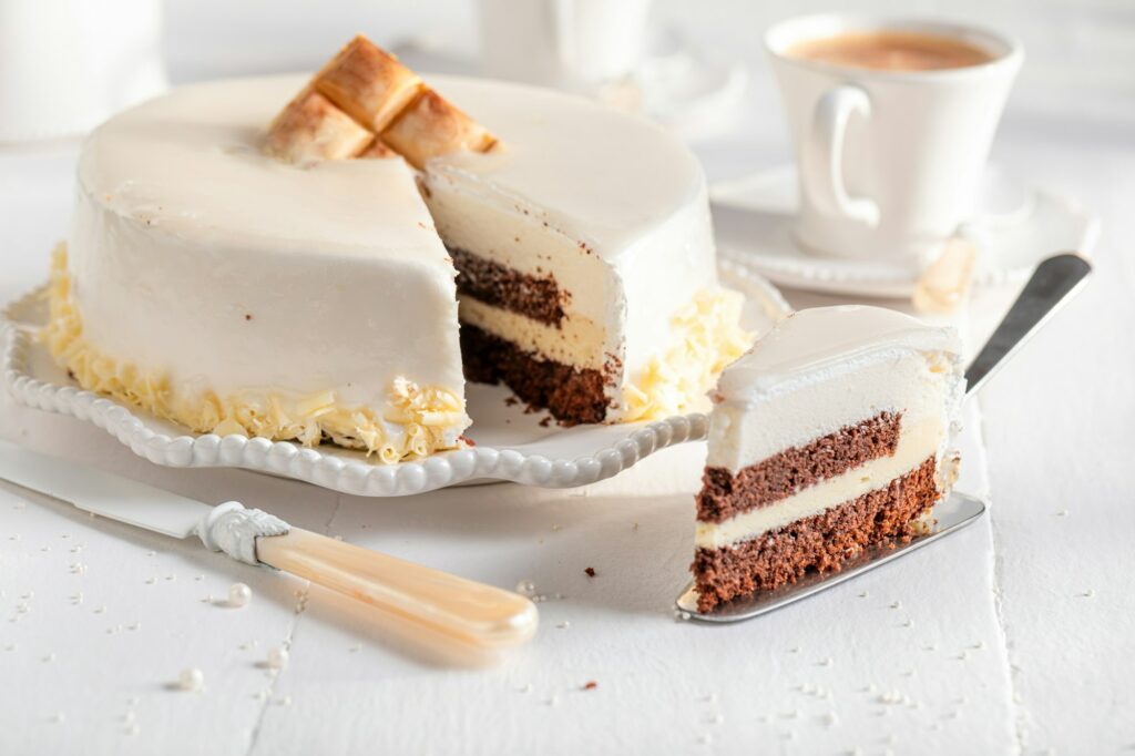 Luxury white chocolate cake served with coffee in white porcelain.